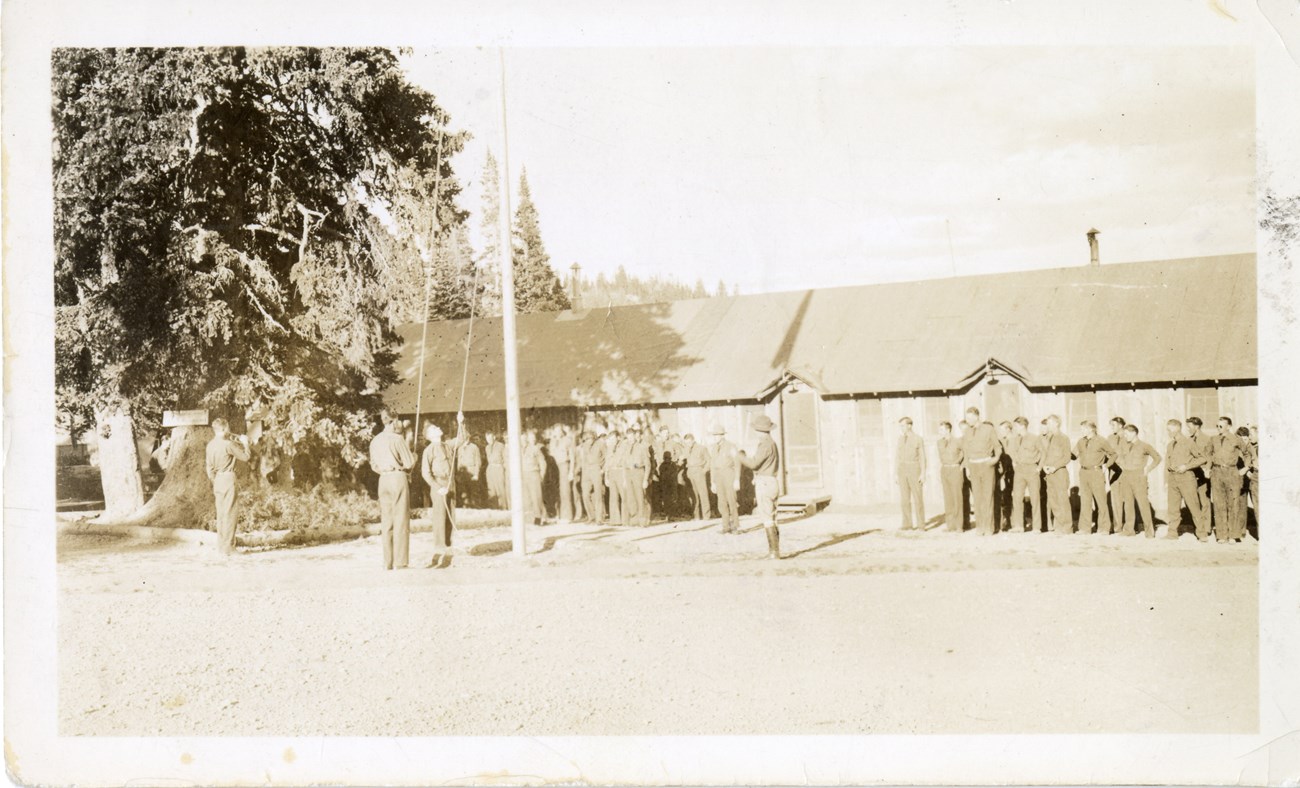 According to Glen Bair, a CCC man stationed in Zion 1933-1934, "We raised the flag every morning, then you would get on the trucks and you would go to work." This image is a snapshot of the flag raising at Cedar Breaks National Monument.