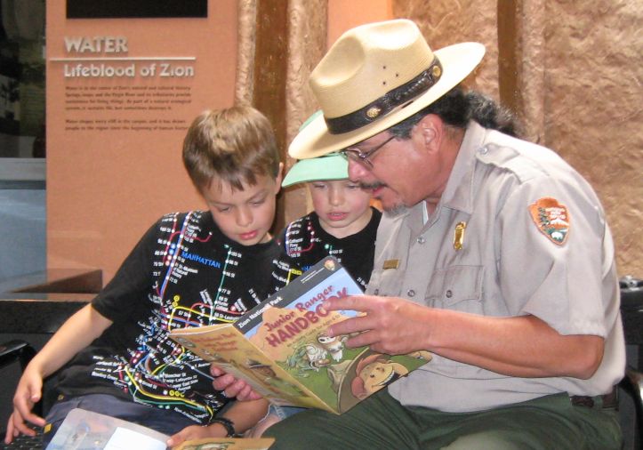 A ranger reviews the Junior Ranger Handbook. A ranger reviews the Junior Ranger Handbook.