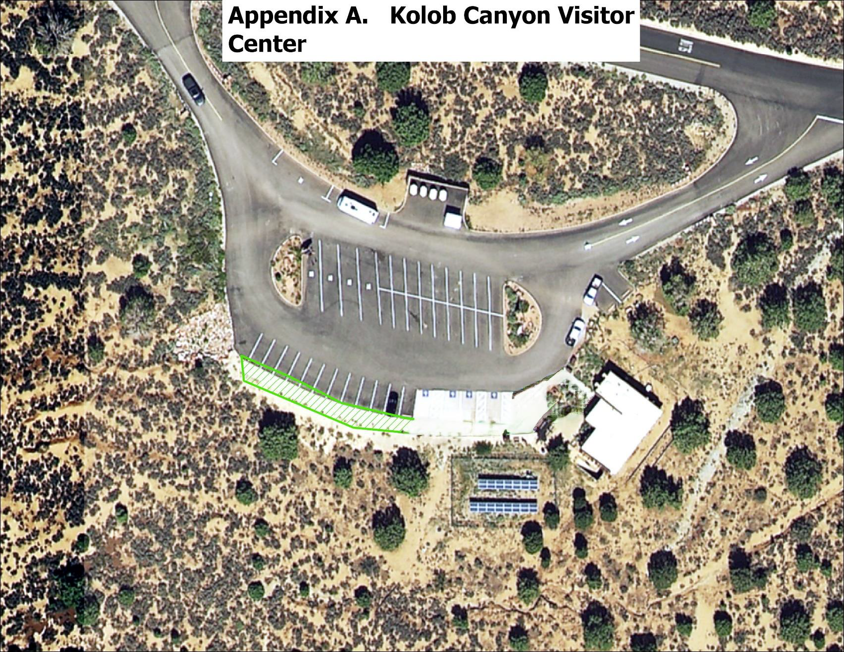 A satellite image showing a parking lot next to the Kolob Canyons Visitor Center. The sidewalk area lining the southern edge of the parking lot is highlighted green, specfically the sidewalk along the non-disability parking spaces.