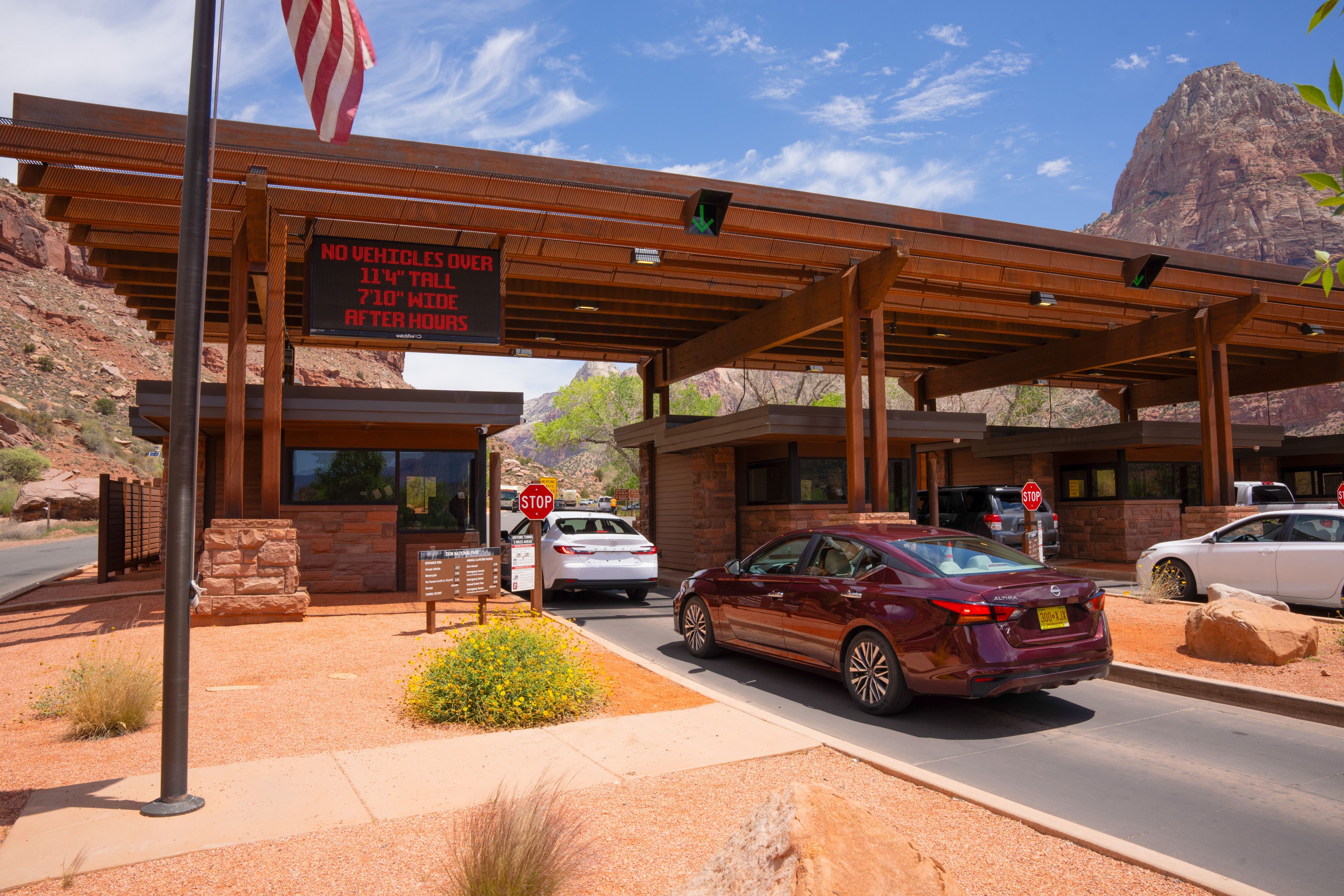 A red car waits in line at the South Entrance to Zion National Park.