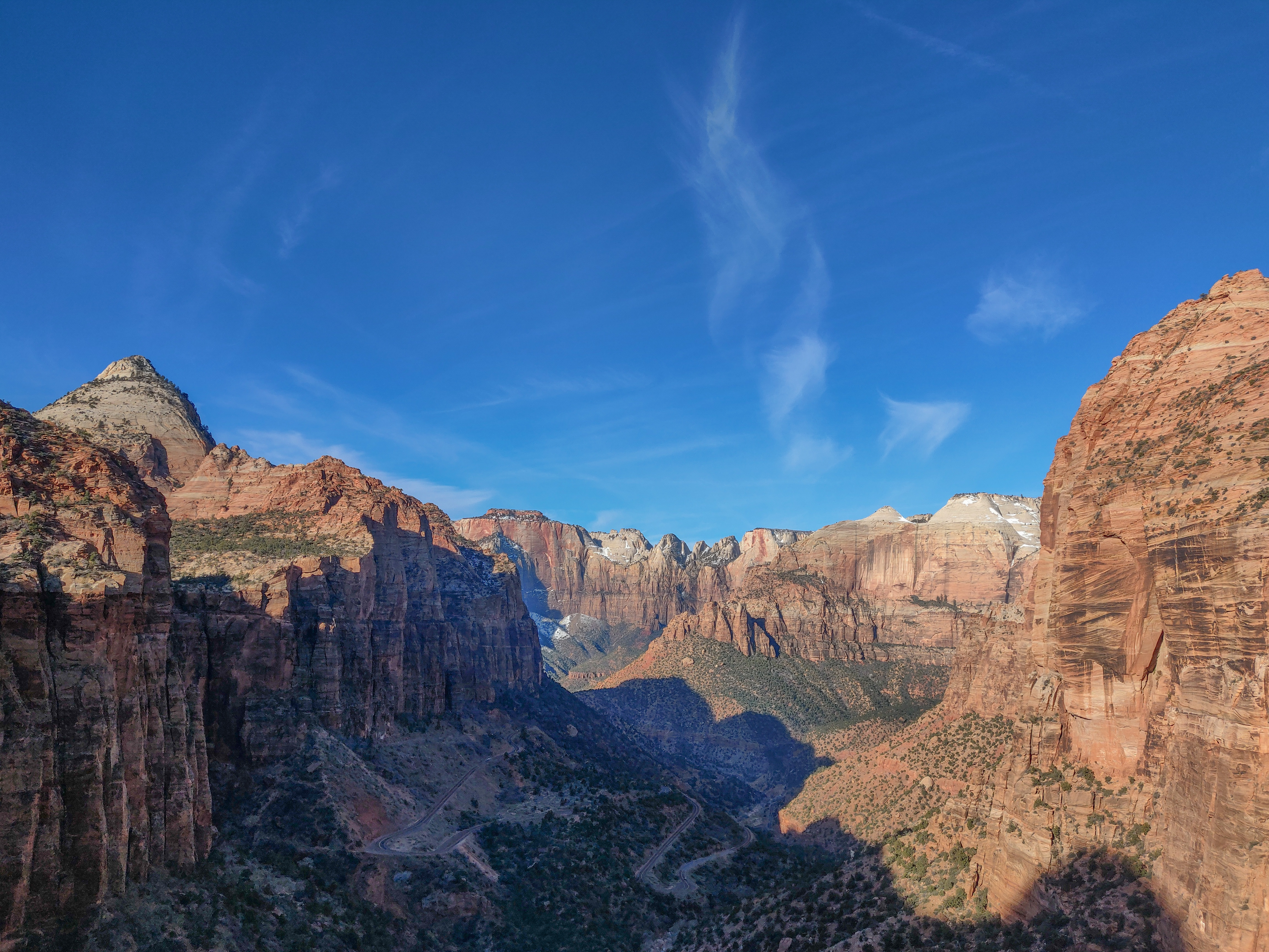 Red rock walls of Zion National Park rise above State Route 9 at Canyon Overlook