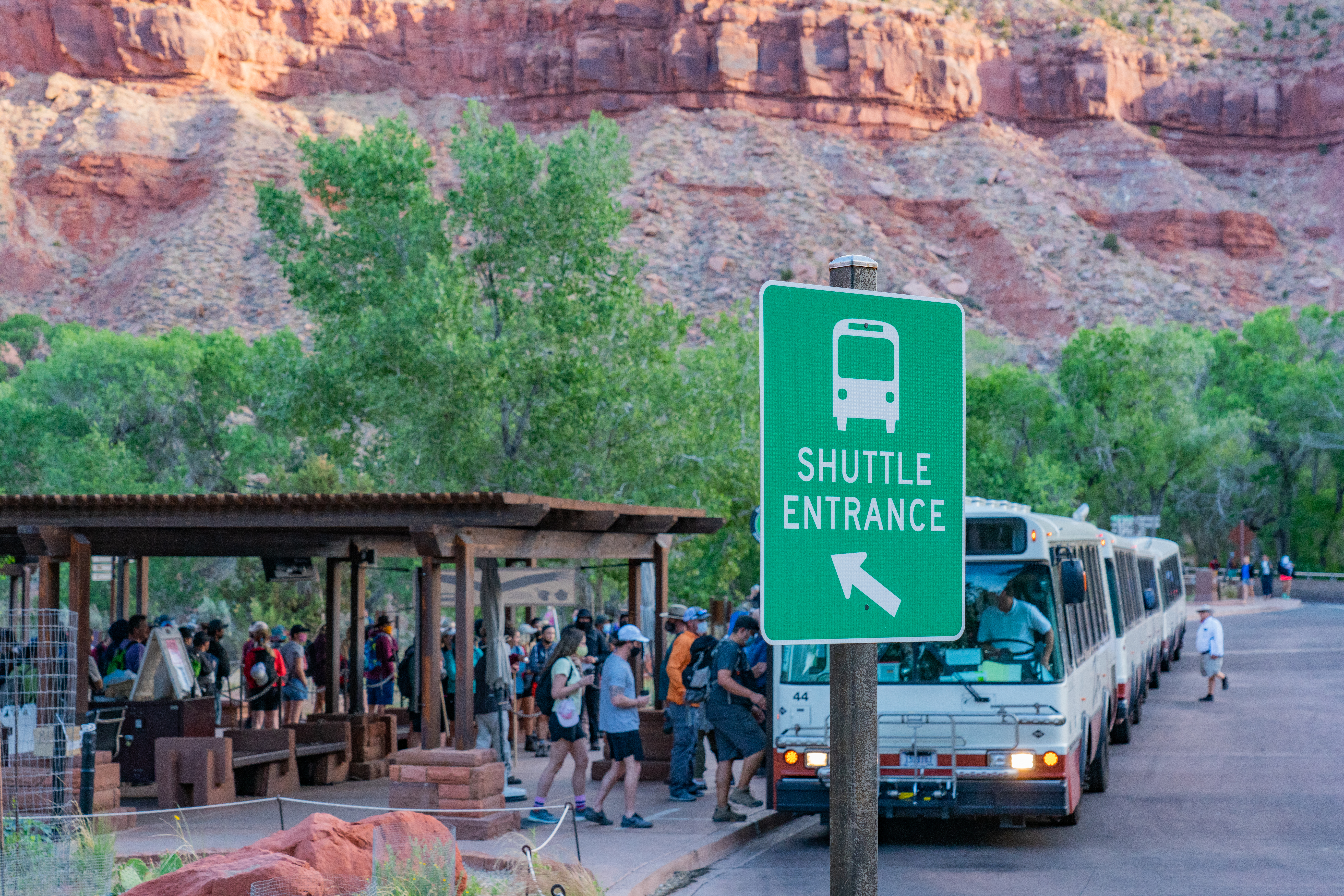 Zion Canyon Shuttle System. Visitors standing in line to board shuttle bus.