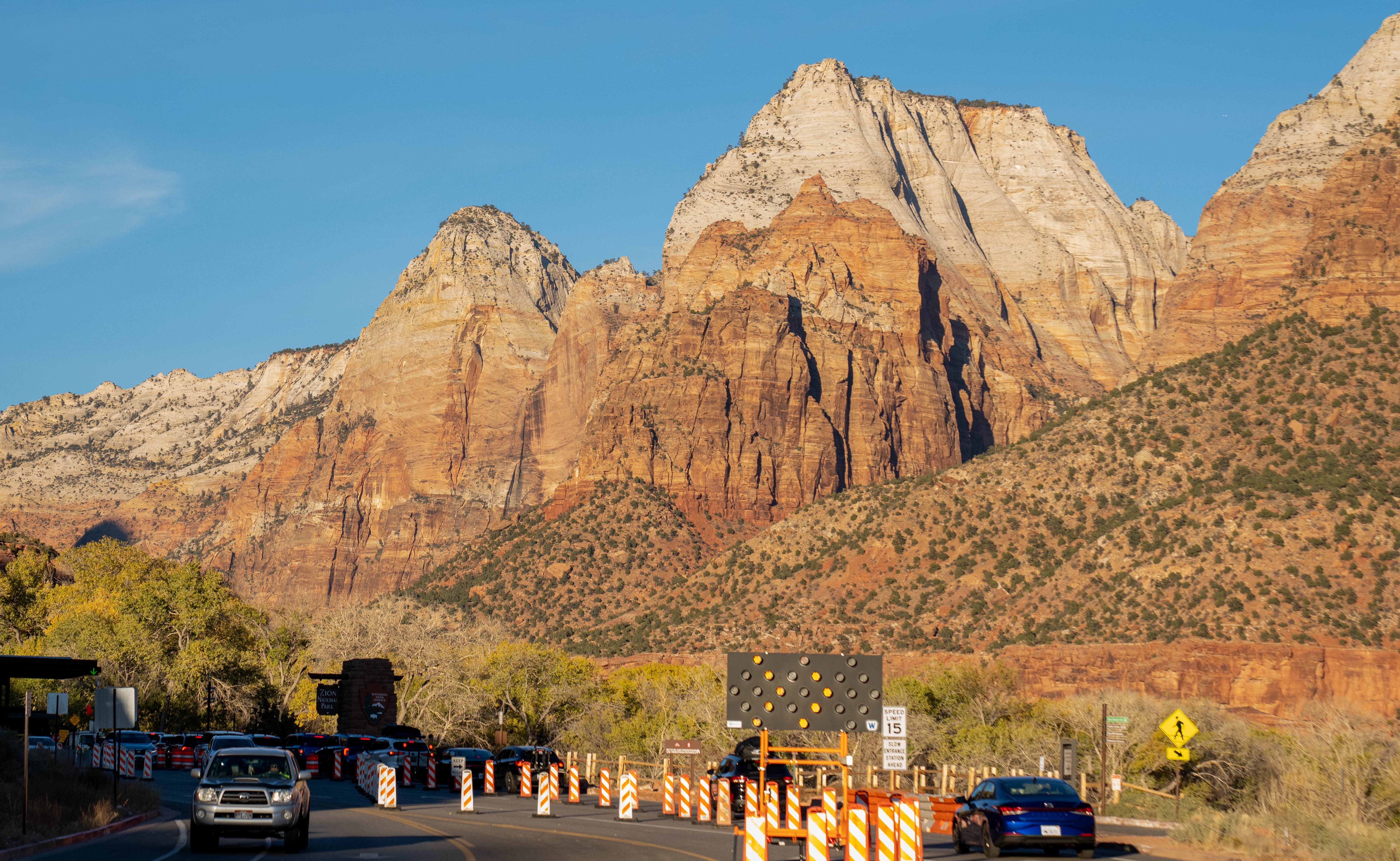 Zion Drainage Improvement Project in process. Cars line up near construction barrels near South Entrance of Zion National Park.