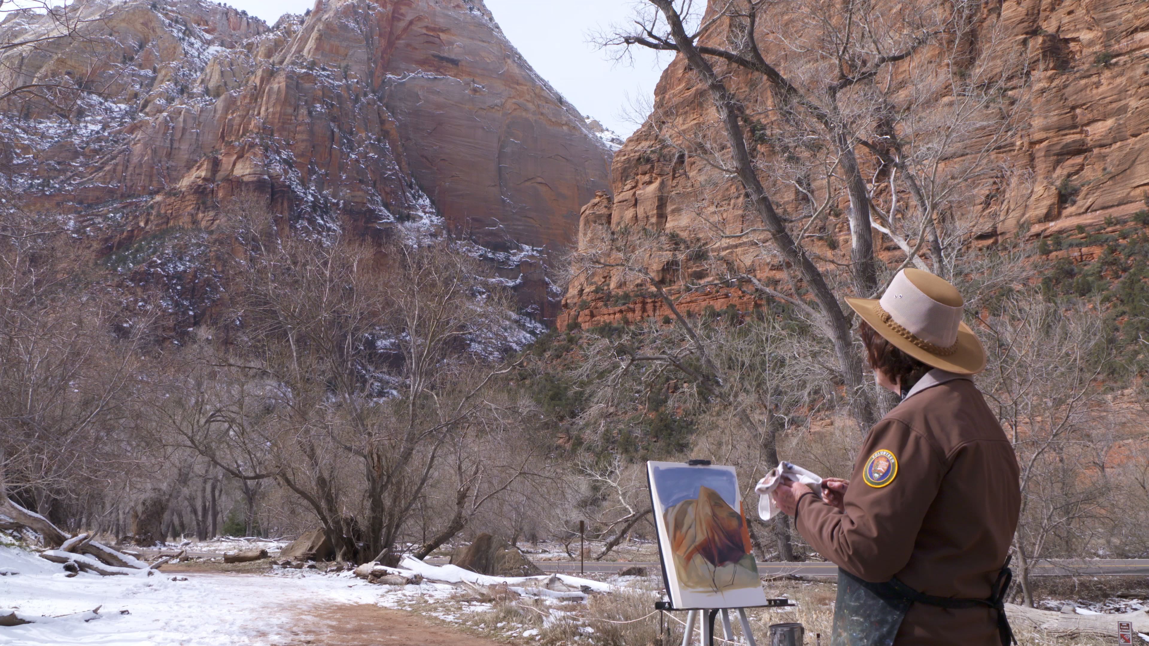 Zion February 2023 Artist in Residence An artist paints a canyon wall outside looking at a canyon wall