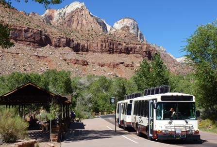the shuttle bus at the visitor center stop with canyon walls in the background