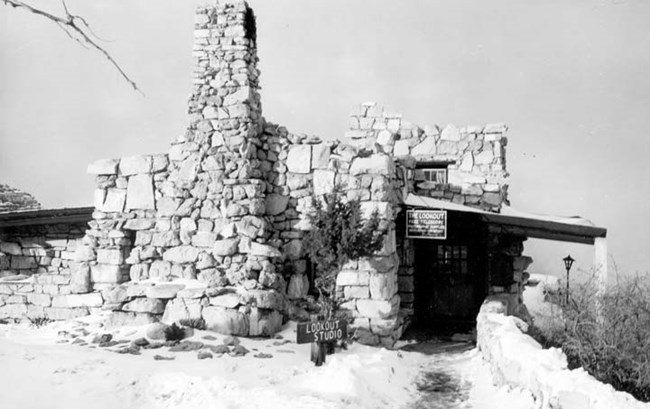 Stone building on the canyon's rim. On the left, there is a large chimney attached.