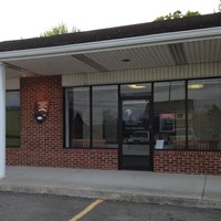 A national park visitor center occupies a store front in a brick commercial building.