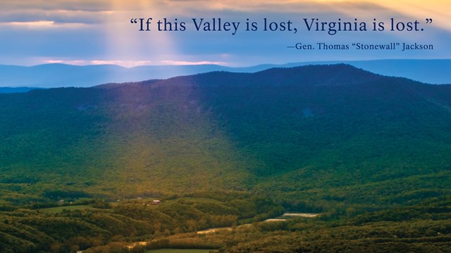 An exhibit panel titled shows sunbeams on a green mountain valley with interpretive text.