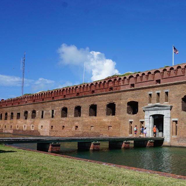 A brick fort surrounded by sand and water