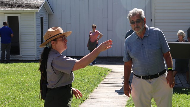 A park ranger talks to a visitor outside 