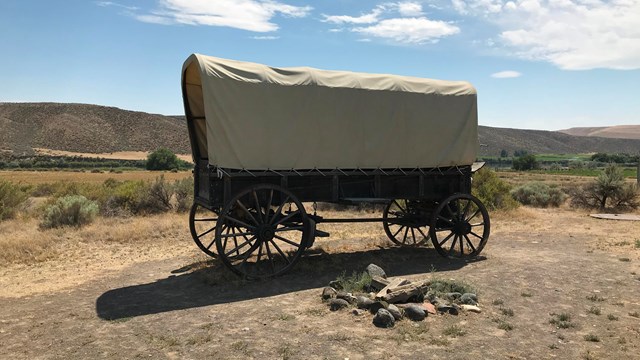 A covered wagon in a desert setting.