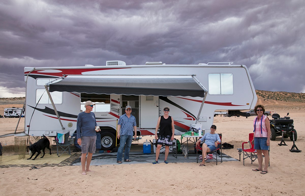 Group stands outside an RV complete with all the recreation trimmings