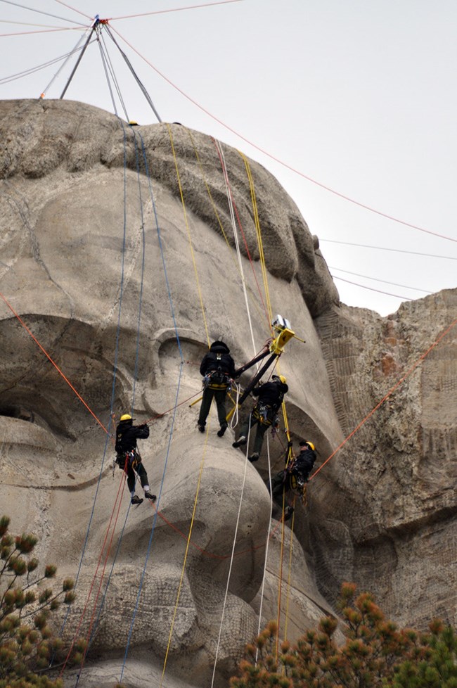 Mount Rushmore's rope access team scans Theodore Roosevelt. Mount Rushmore's rope access team scans Theodore Roosevelt.