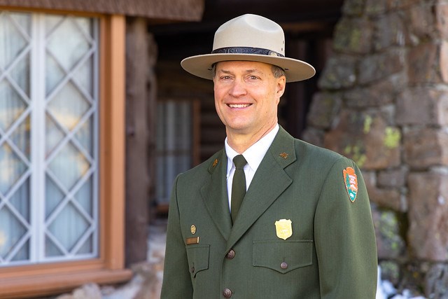 An employee in uniform standing outdoors smiling at the camera